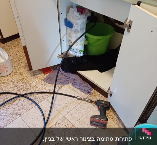 כלי עבודה של אינסטלטור מתחת לכיור במטבח